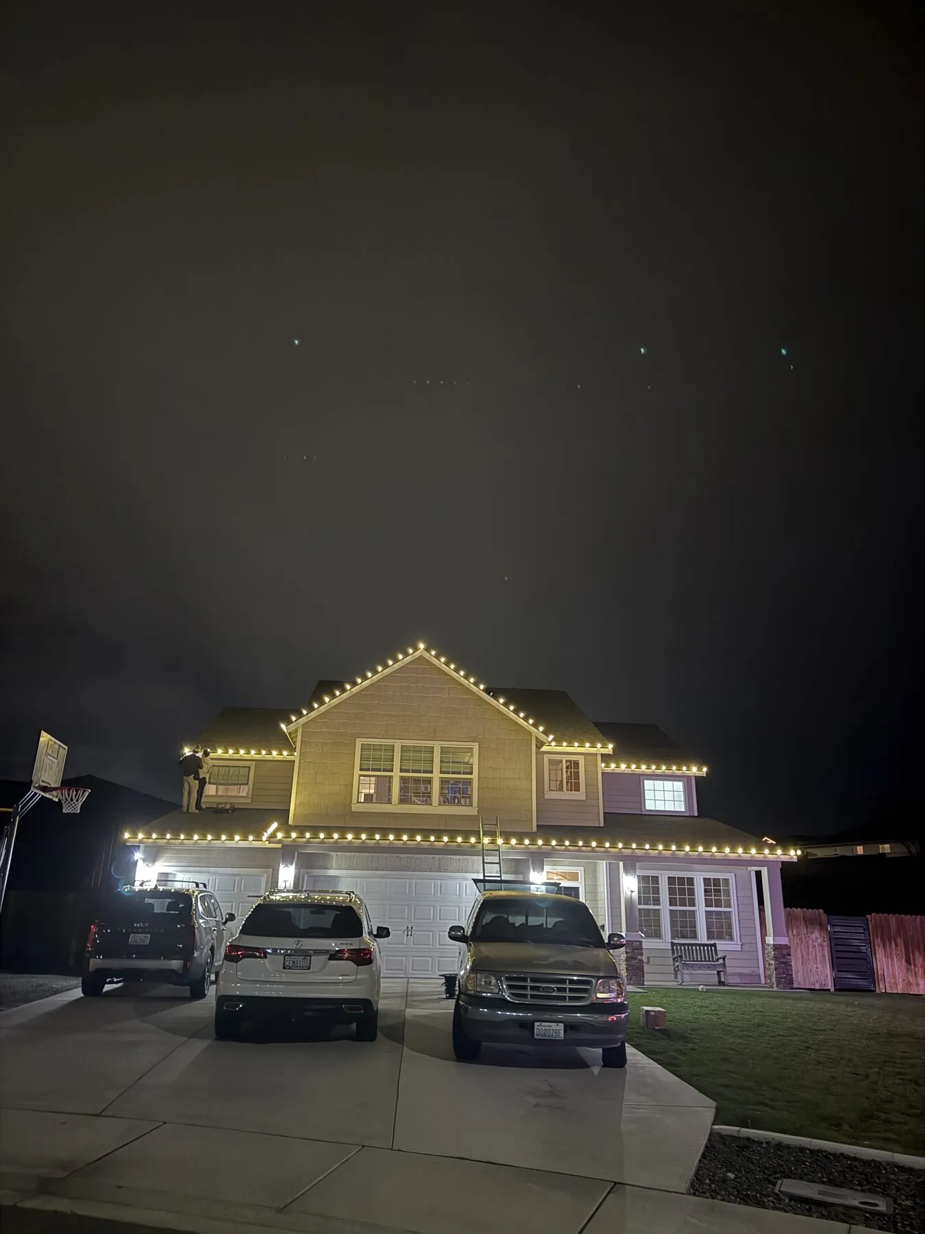 Two-story home with warm white roofline lights